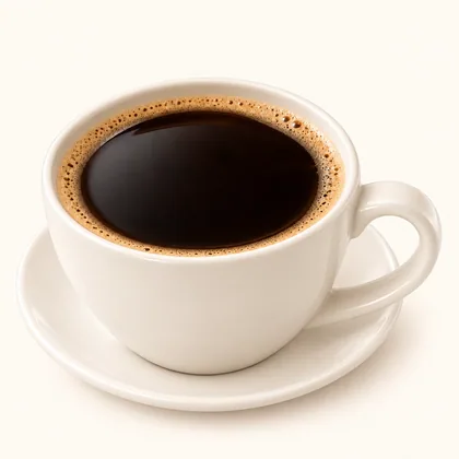 Café americano servido en taza crema sobre un plato pequeño.