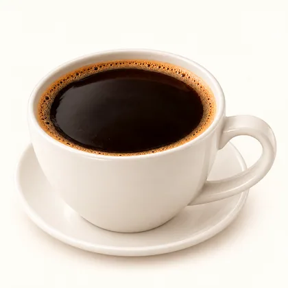 Café montañero oscuro servido en taza crema sobre un plato pequeño.