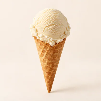 Cono de galleta con una bola de helado color crema sobre fondo marfil.