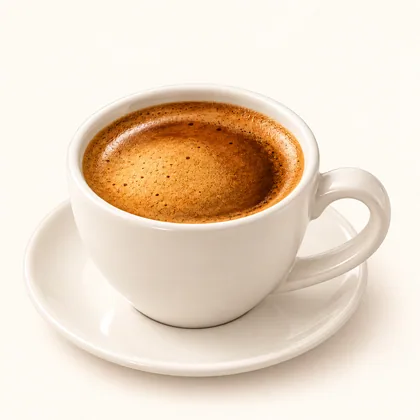 Doble espresso con crema avellana servido en taza crema sobre un plato pequeño.