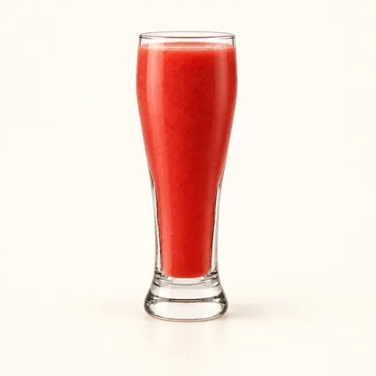 Jugo de fresa rojo rosado servido en un vaso alto de vidrio transparente.