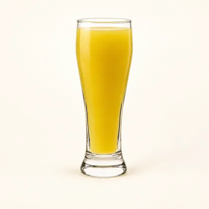 Jugo de lulo amarillo dorado servido en un vaso alto de vidrio transparente.
