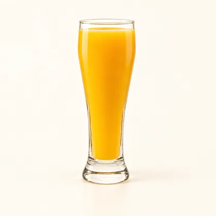 Jugo de mango amarillo anaranjado servido en un vaso alto de vidrio transparente.