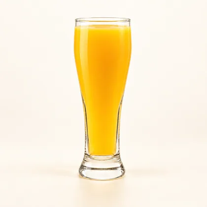 Jugo de maracumango amarillo anaranjado servido en un vaso alto de vidrio transparente.