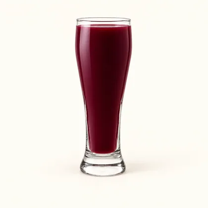 Jugo de mora color morado profundo servido en un vaso alto de vidrio transparente.